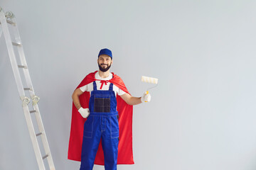 Happy home painter worker engaged in house renovation, holding roller brush, wearing superhero...