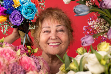 Portrait of a woman aged, different flowers around her, the concept of skin and health care in general, self-care at any age