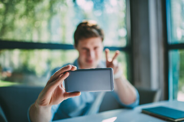 Thoughtful hipster blogger updating profile on telephone