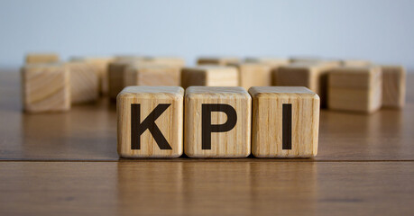 Concept word 'KPI' on cubes on a beautiful wooden table. White background. Business concept.