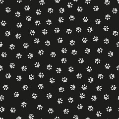 Doodle white paw print seamless fabric design repeated pattern with black background