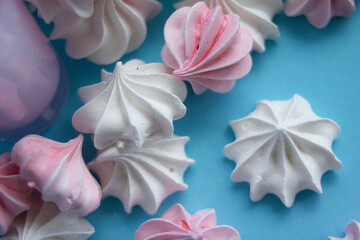 Fototapeta na wymiar Sweet delicate meringues on a blue background 