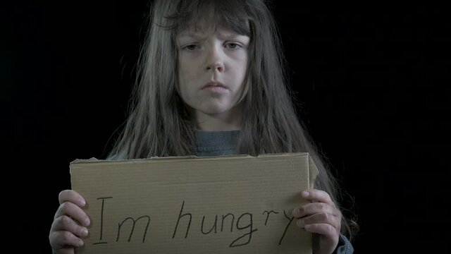 Hungry beggar. Sad hungry homeless little girl holding a sign I'm hungry.