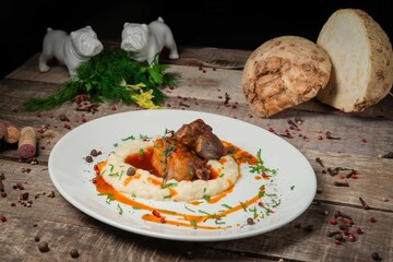 Baked duck leg with mashed potatoes, fresh bread .On a white plate. On a rustic wooden background
