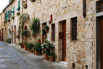 Fototapeta na wymiar Ancient Italian street.Streets of Italy.Medieval street with flowers.Stone houses, flower lane. Old beautiful Tuscan streets in the Italian town.