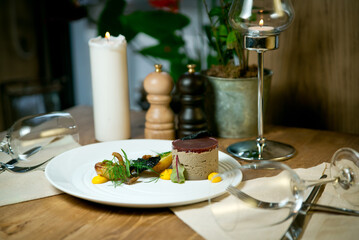 Liver pate with baked potatoes and fresh herbs .On a white plate. On a served wooden table