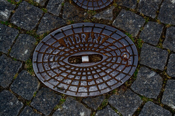 Old manhole in the city with the inscription 
