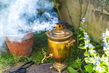 Old vintage samovar with smoke. Brewing tea in the old fashioned way. Russian ceremony
