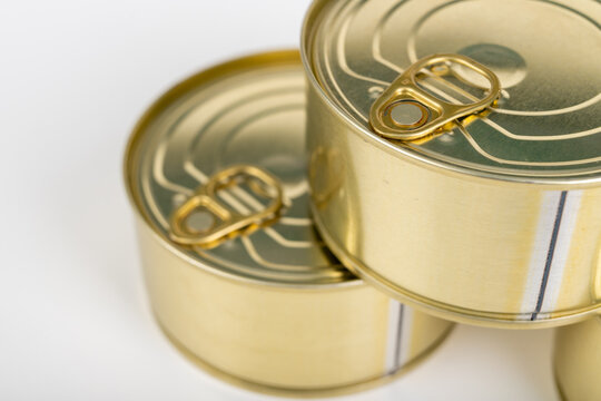 A metal tin cans on a white table. Food with a long shelf life.