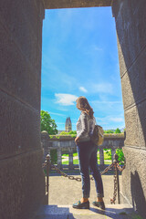 Woman standing between walls and looking outside  to a cityscape view