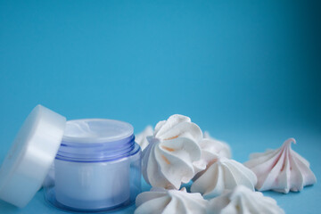 Beautiful blue cream jar with meringues on a blue background
