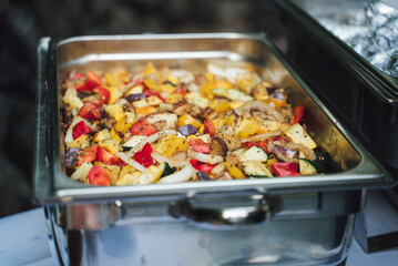 Mix of colorful grilled vegetable in stainless hotel pan on buffet table. Celebration, party, birthday or wedding concept.