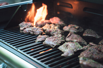 Several steaks on grill. Meat pieces, preparation of meal. Selective focus. Celebration, BBQ, party concept