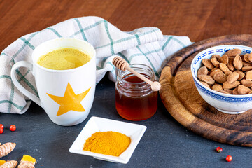 Turmeric tea or golden milk has been venerated since ancient times for its healing properties. Table set with ingredients