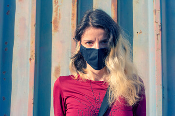 Obraz premium Portrait of a young, blonde woman wearing a copper filter mask that blocks almost 99% of the bacteria during the pandemic
