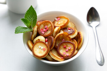 Breakfast with mini pancakes, little hearts and mint. Trendy food concept and pleasant breakfast