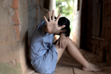 Young girl sitting on the floor with showing stop hand for stop violence and rape,