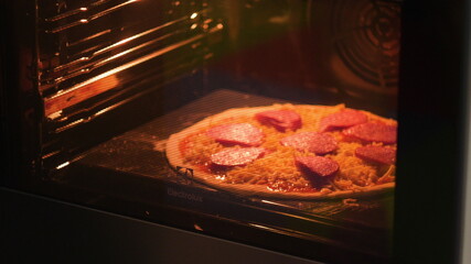 Woman or man put in the oven pizza for baking. A man or woman is engaged in home business