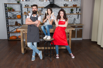 Fototapeta premium happy family day. father and mother with daughter cook in kitchen. little girl cooking with parents. love and support. healthy food concept. professional chef team. happy childhood