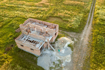 Aerial view of building site for future house, brick basement floor and stacks of brick for construction.