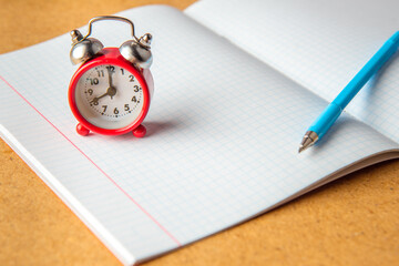 Back to school concept. old alarm clock on a clean notebook. Copy space.