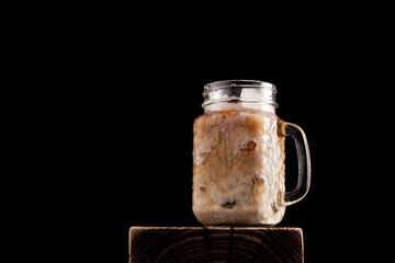 Iced latte coffee in cup glass on black background. Close-up, copy space
