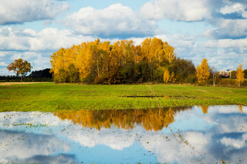 Landscape of the valley in Europe, Cloudy sky and autumn colors, water reflection.