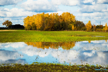 Landscape of the valley in Europe, Cloudy sky and autumn colors, water reflection.