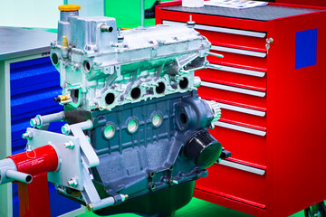 Car engine diagnostics in the workshop. The engine is mounted on a bracket against the background...