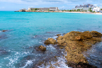 Hotels and resorts on coastline of Caribbean island coast. White sand beach shore tropical setting and scenic ocean views.