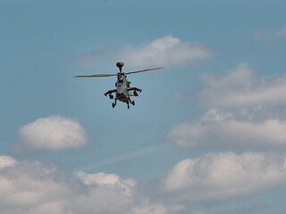 In the distance a green military helicopter is approaching.