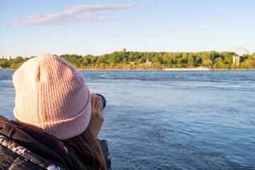 tourist on Montreal old port pier searching the humpback whale in the saint lawrence river