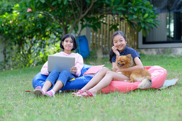 Fototapeta premium schoolgirl asia studying online lesson at home with teacher. Elementary school student Listen to teachers teach online at home.homeschooling