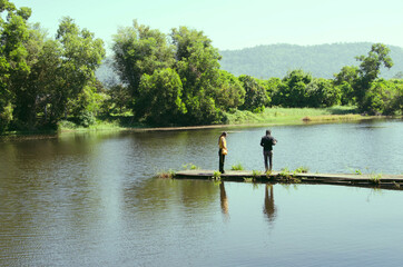 Fototapeta na wymiar Love couple on bridge in river with reflection