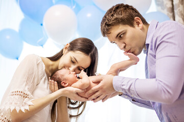 Young couple holding and kissing newborn baby boy