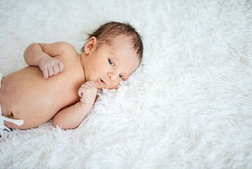 Newborn baby boy lying down on bed