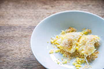 Close up mung bean rice-crepe in a white plate with wooden spoon on rustic wooden table.