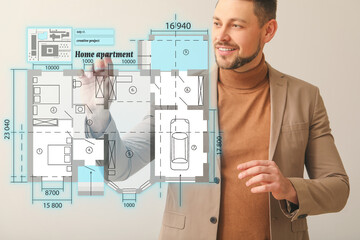 Male architect with virtual plan of building on light background