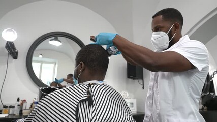 Barber shaving hair of a customer in barber shop