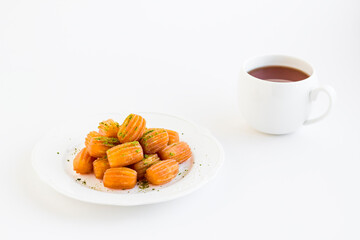 Traditional Turkish Crispy,Pastry Dessert Tulumba in the white porcelain plate on white with copy space and drink