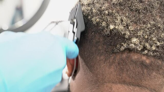 Barber shaving hair of a customer in barber shop