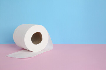 Roll of toilet paper on color background