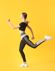 Sporty running young woman on color background