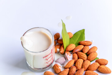 Almond milk in glass with almonds on wooden table
