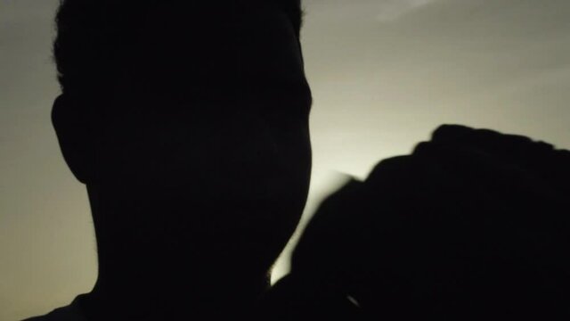 Dramatic silhouette of baseball pitcher as he prepares to throw ball.