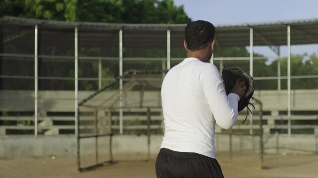 Dominican Baseball pitcher practices his pitch during early morning sunrise.