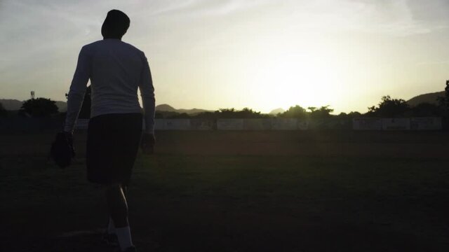 Dominican Baseball pitcher practicing in early morning sunrise.