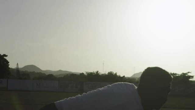 Baseball pitcher in silhouette practices in the Dominican Republic.