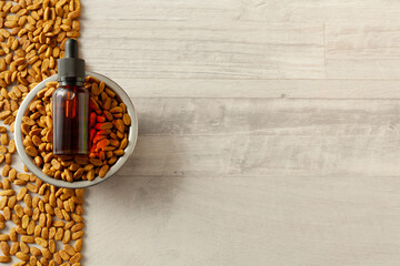 pet food in an iron bowl, on top is a jar of oil, wooden background, free space for text