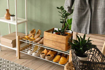 Stand with stylish shoes in interior of modern hall